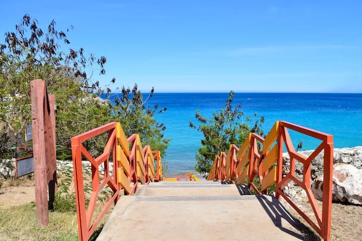 Orange railing and walkway leading to the sea in Westpunt