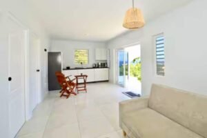 Villa living area with sofa and dining table and open terrace door